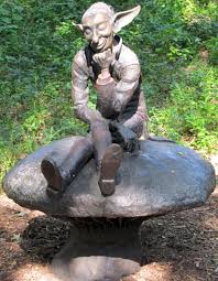 Statue de lutin assis sur un rocher